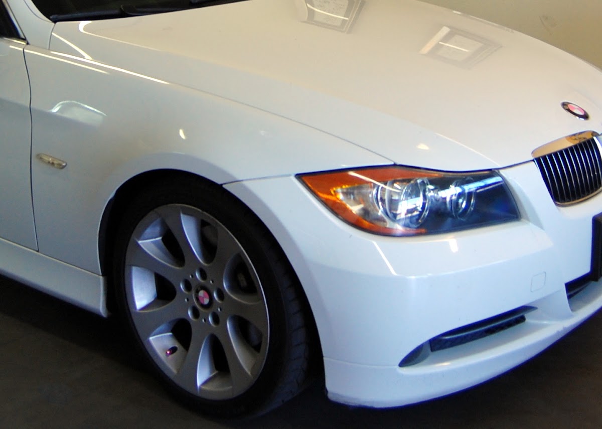 A white BMW sedan in the shop bay